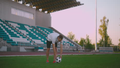 Set-the-socker-ball-on-the-lawn-run-and-hit-the-ball-in-the-stadium-with-a-green-lawn.-A-professional-soccer-player-kicks-the-ball-in-slow-motion